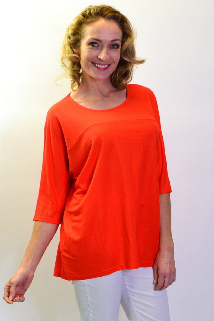 Bright orange Stylius sloping sleeve tunic top in soft jersey fabric, shown on a hanger against a white background.