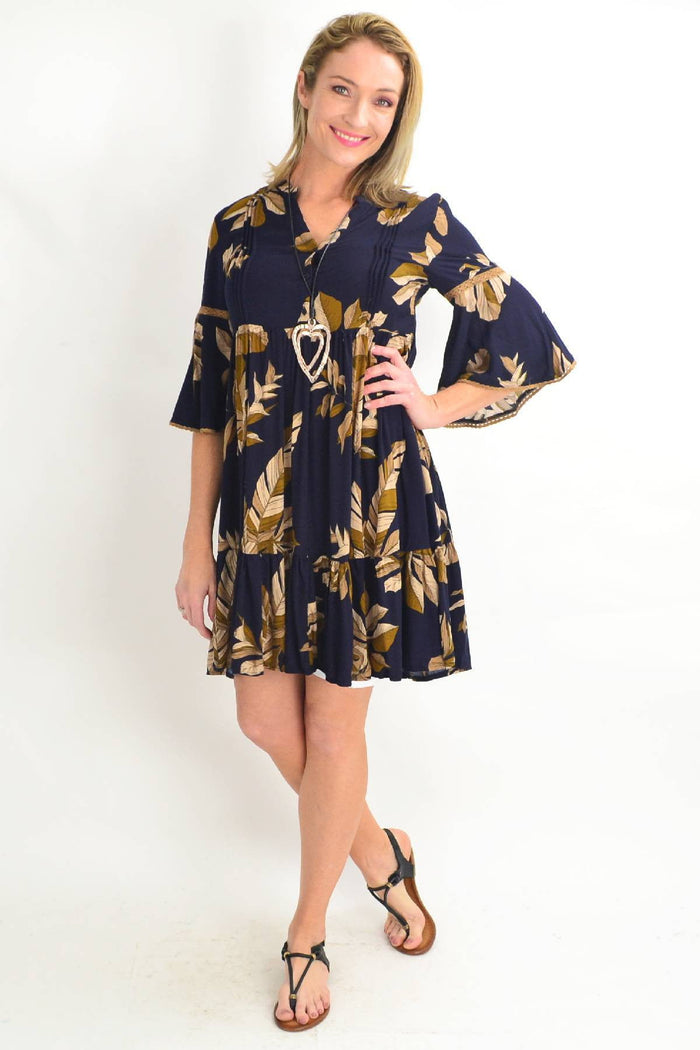 Willow Tree navy bell cuff tropical leaf tunic dress displayed on a hanger with a tropical leaf pattern and bell cuff sleeves.