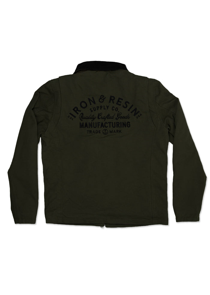 Dark green jacket with "Iron & Resin Supply Co." logo on back, showcasing quality crafted goods and manufacturing trademark.