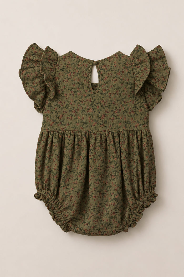 The Ivy City Co Baby Hattie Romper in Woodland Floral features an olive green hue with a delicate small floral print, short flutter sleeves, a gathered waist, elastic leg openings, and a back button closure. Crafted from soft cotton, this romper offers everyday comfort and charming style.