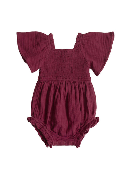 The Ivy City Co Baby Lennon Romper in Wildberry is a maroon cotton romper for babies with short ruffled sleeves, a smocked bodice, and elastic leg openings, shown on a white background.