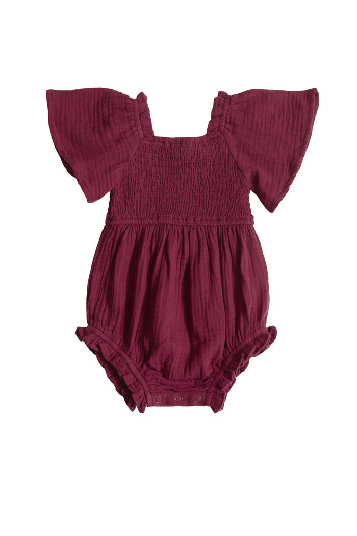 The Baby Lennon Romper in Wildberry by Ivy City Co is a maroon cotton baby romper featuring flutter sleeves, a smocked bodice, and ruffled leg openings, displayed against a white background. This charming piece combines comfort and style for your little one.