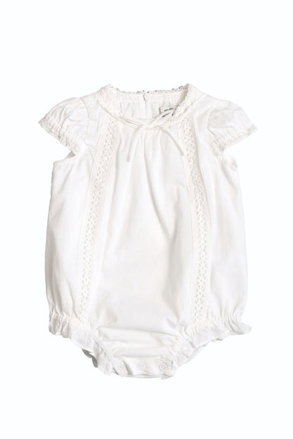 The Baby Palermo Romper in White by Ivy City Co features short puff sleeves, lace trim, bottom snap buttons for easy changes, and soft lightweight fabric—perfect for summer comfort and adorable Mom and Me matching looks.