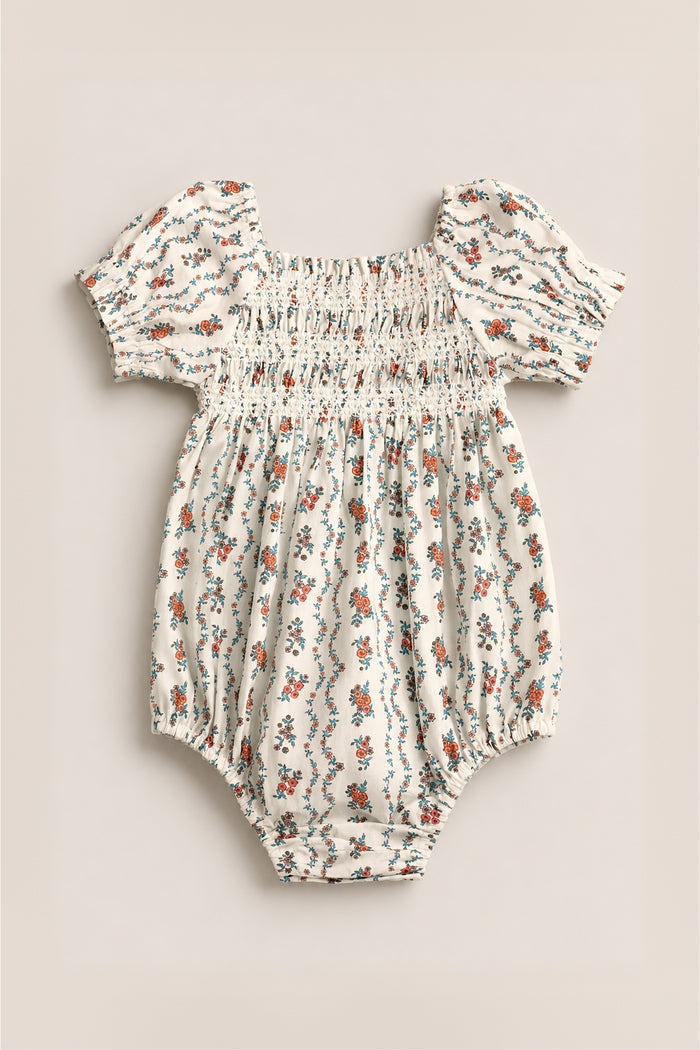 The Ivy City Co Baby Sunday Best Romper in Linear Poppy Woodblock is cream-colored with puffed short sleeves, elastic details, and a delicate orange and blue poppy print—perfect for matching Mom and Me outfits.