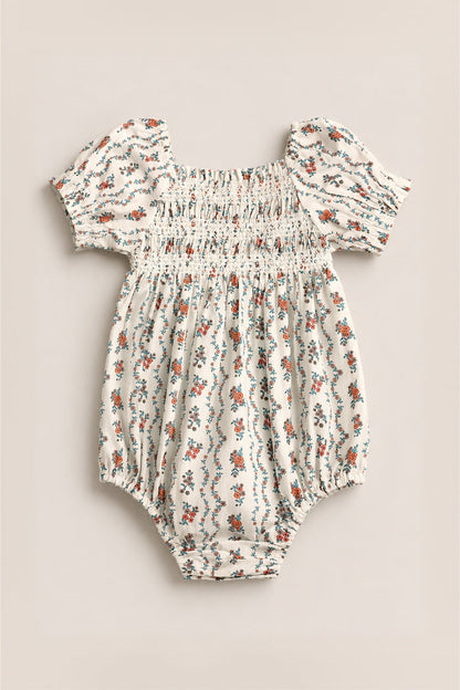 The Ivy City Co Baby Sunday Best Romper in Linear Poppy Woodblock is cream-colored with puffed short sleeves, elastic details, and a delicate orange and blue poppy print—perfect for matching Mom and Me outfits.