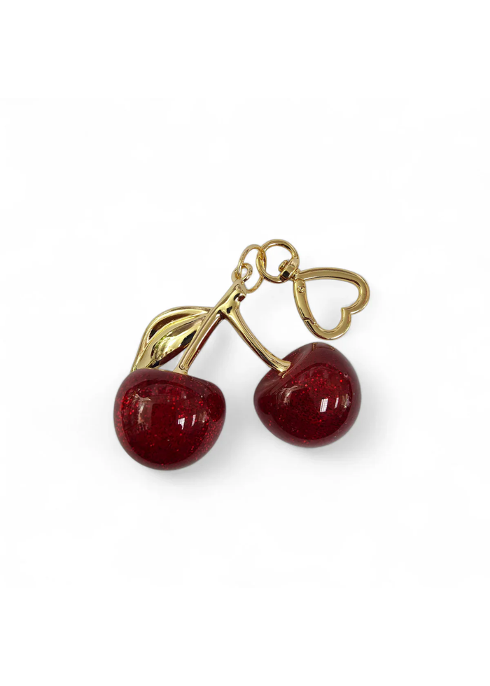 Red glitter cherry bag charm with a gold heart clasp on a white background