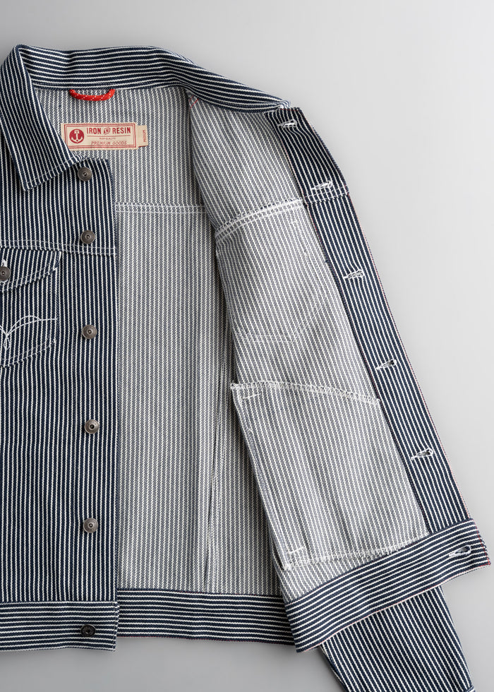 Blue and white striped jacket with open front, revealing label "Iron and Resin" inside. Button details visible on the left side.