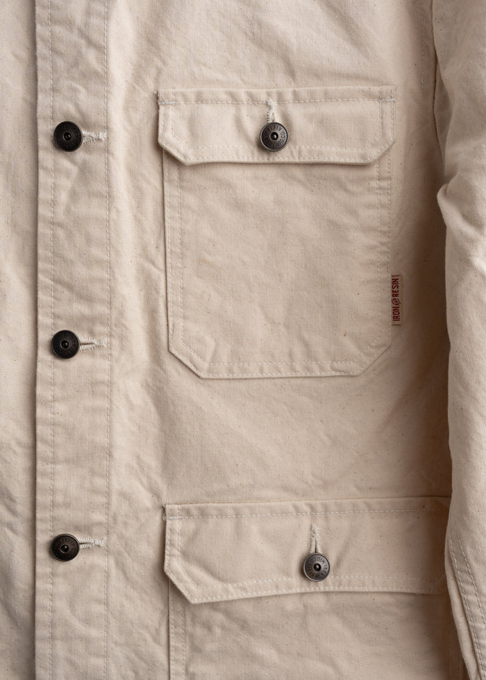 Close up of front pocket layout on canvas jacket, showcasing custom buttons, storage and stitching detail