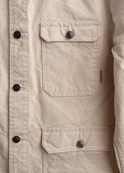 Close up of front pocket layout on canvas jacket, showcasing custom buttons, storage and stitching detail