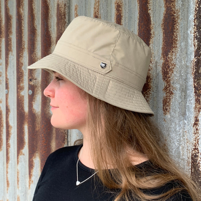 Woman wearing light sand coloured Hydroex rain hat.