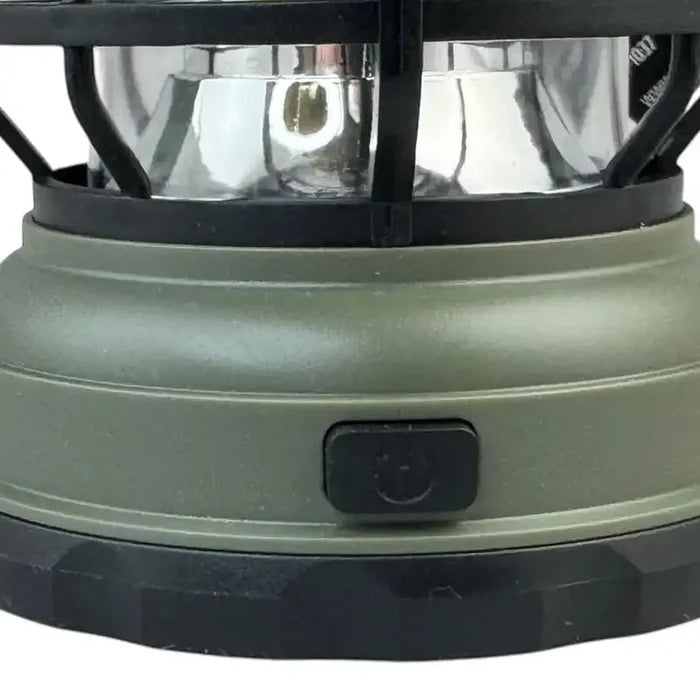 Close-up of a green camping lantern with a black switch