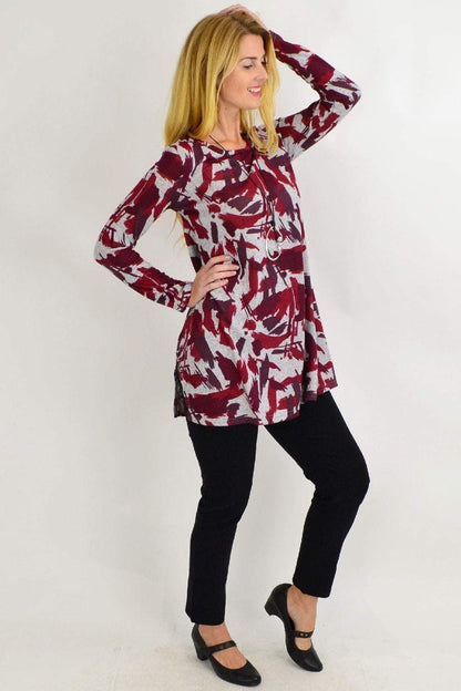 Red and grey paint splash fleece tunic top by Hourglass, featuring a vibrant, artistic design on a comfortable, casual garment.