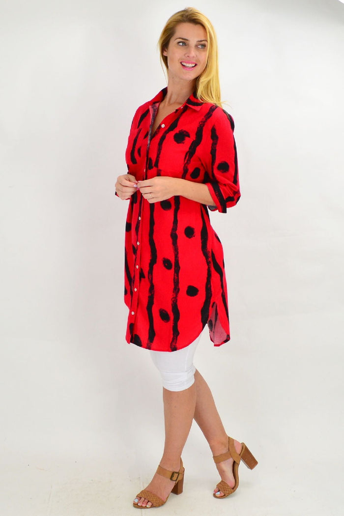Red Ruby Rain tunic shirt with black dot pattern, featuring a relaxed fit and long sleeves, displayed on a hanger.