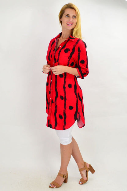 Red Ruby Rain tunic shirt with black dot pattern, featuring a relaxed fit and long sleeves, displayed on a hanger.