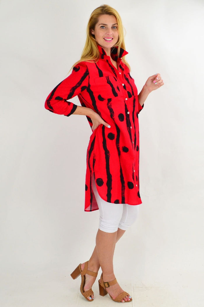 Red Ruby Rain tunic shirt with black dots, featuring a relaxed fit and long sleeves, displayed on a hanger.