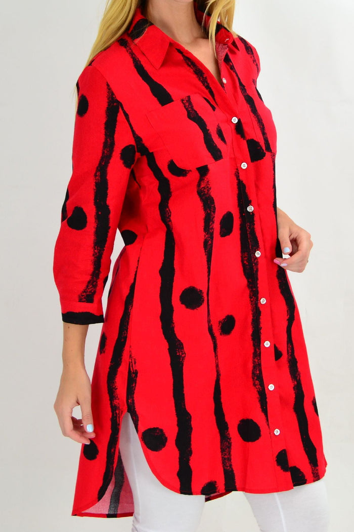 Red Ruby Rain tunic shirt with black dot pattern, featuring a relaxed fit and long sleeves, displayed on a hanger.