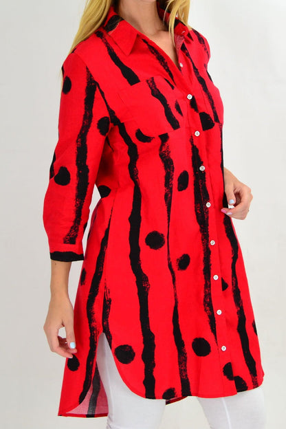 Red Ruby Rain tunic shirt with black dot pattern, featuring a relaxed fit and long sleeves, displayed on a hanger.