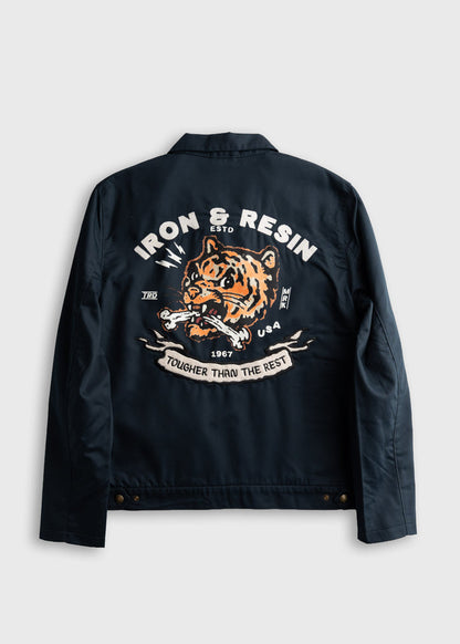 Navy jacket back with a fierce tiger design, "Iron & Resin," and "Tougher Than The Rest" text in bold white and orange.
