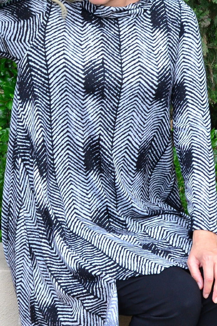 Hourglass zig zag black and grey fleece tunic dress with long sleeves and relaxed fit, displayed on a hanger.