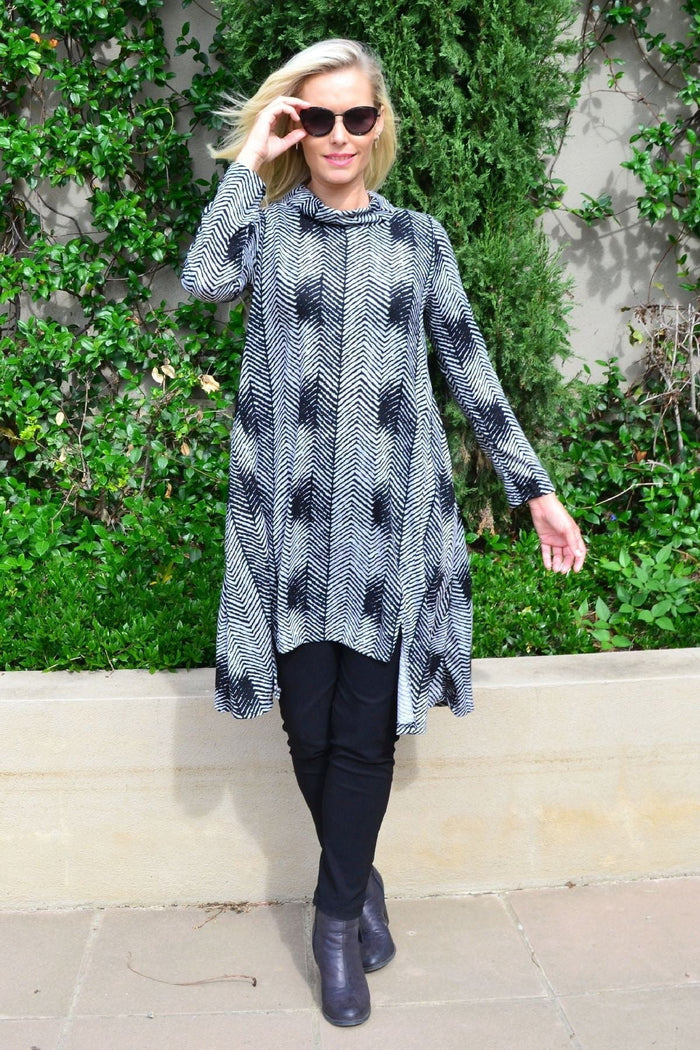 Hourglass Zig Zag Black and Grey Fleece Tunic Dress hanging on a mannequin, showcasing its cozy, stylish design and pattern.