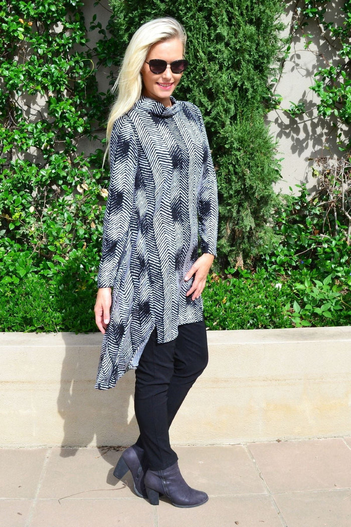 Hourglass black and grey zig zag fleece tunic dress hanging on a hanger, showcasing its relaxed fit and cozy fabric design.